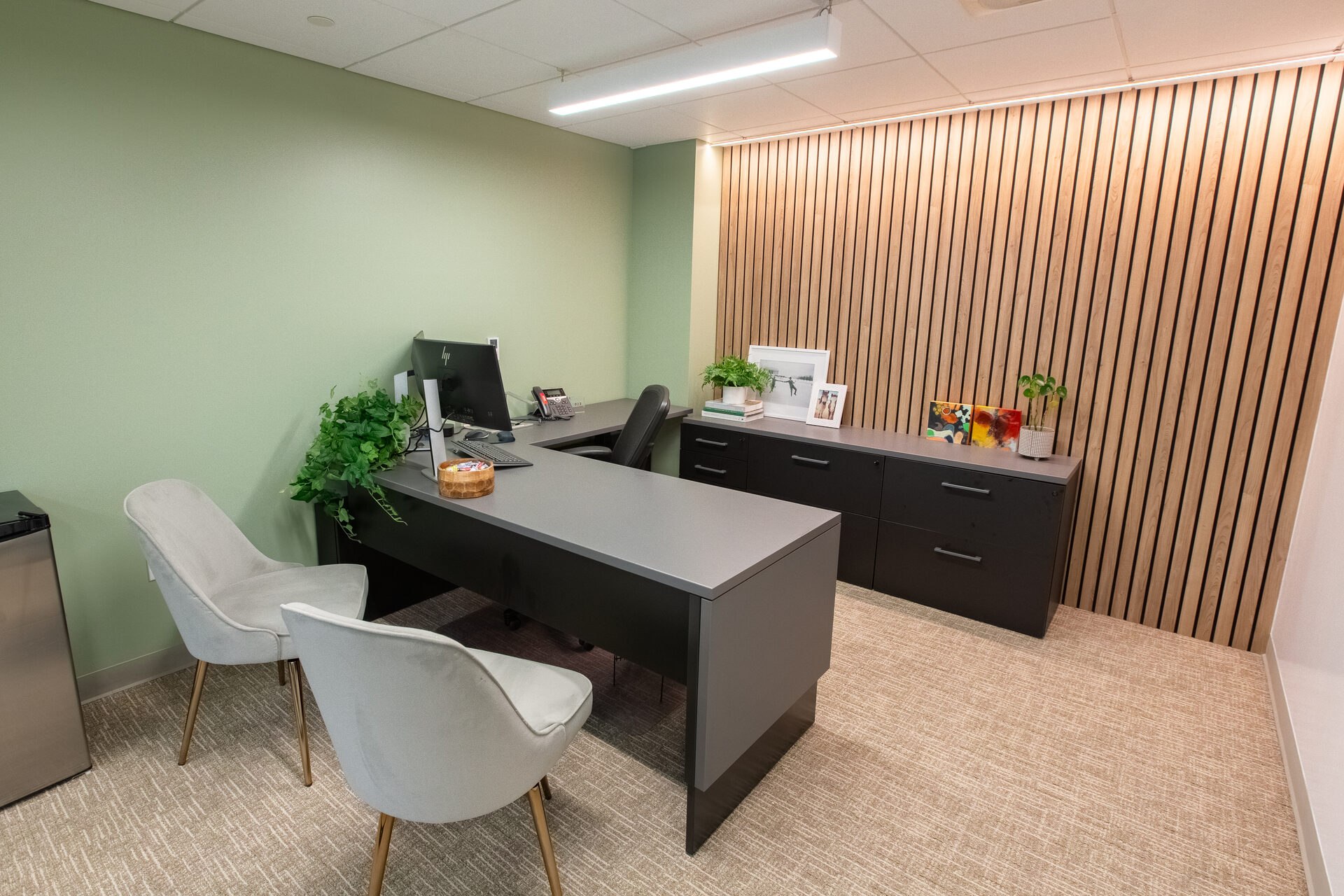 Private office with sage wall and wood slat accent
